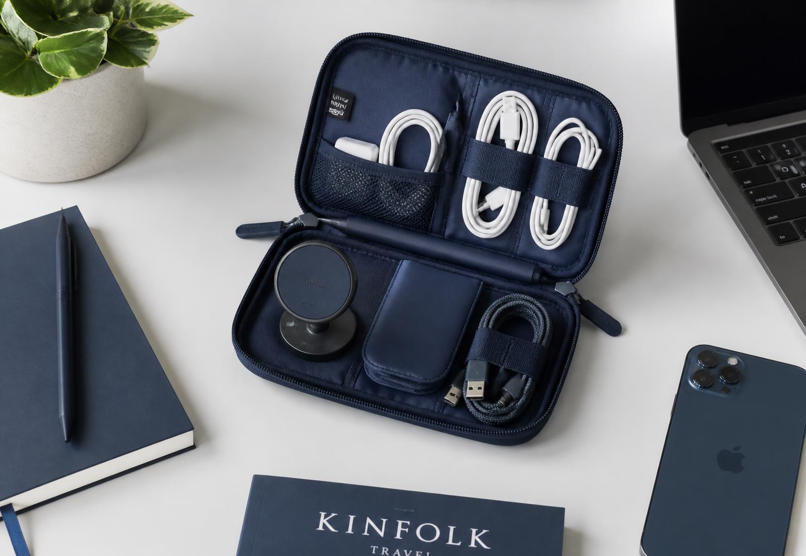 Regintric navy electronics organizer case open on a desk with cables, charger and magnetic mount